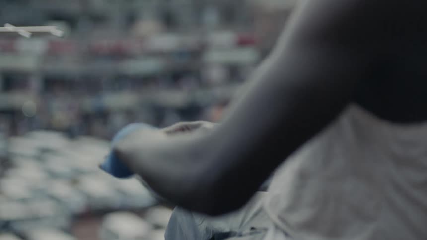 Man on rooftop applies tape to his hand