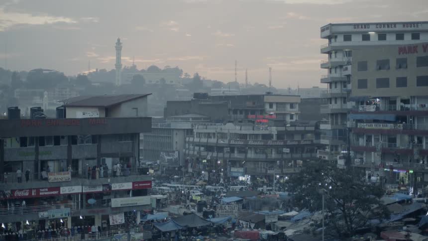 Cars are people bustle in a city at sunset