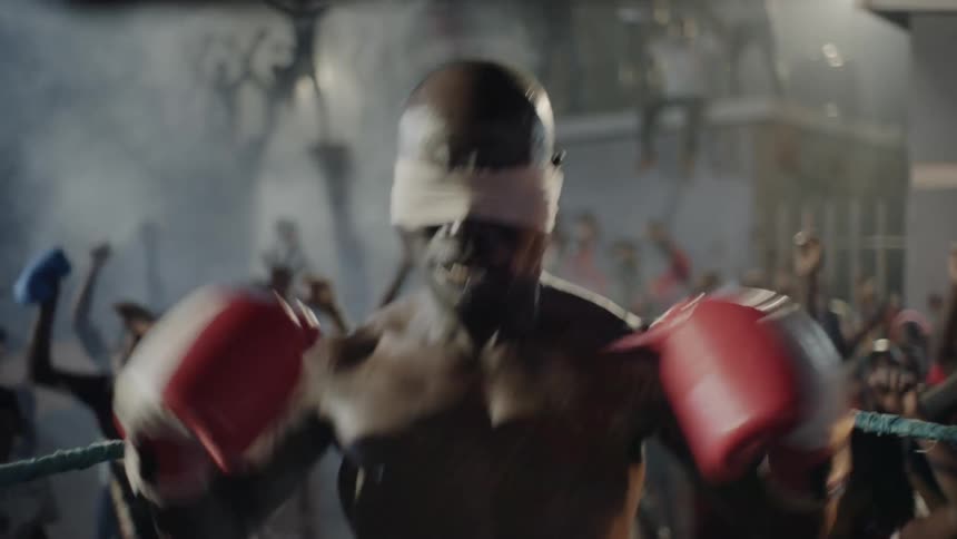 A crowd cheers at an outdoor boxing match