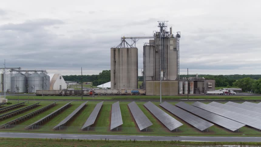 Solar panels and silos sit on a farm