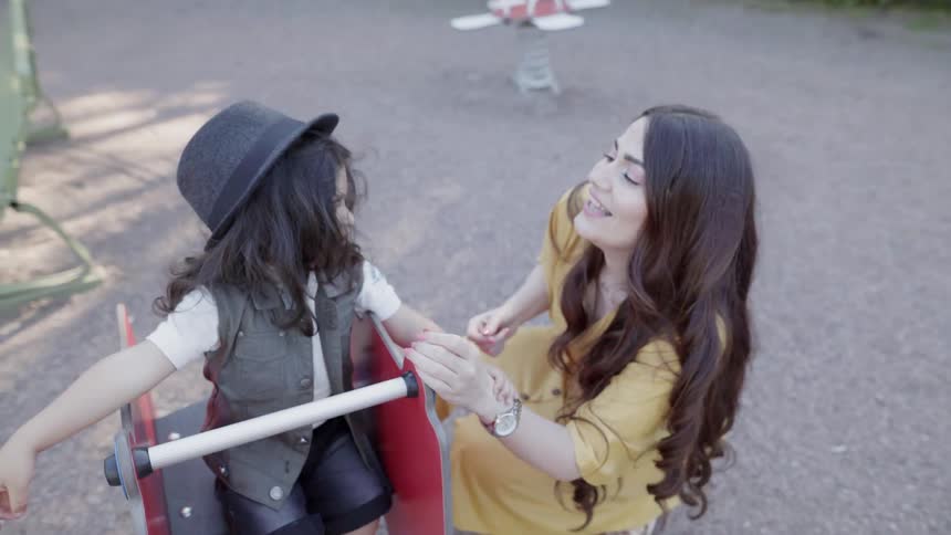 A woman and young child play at a park