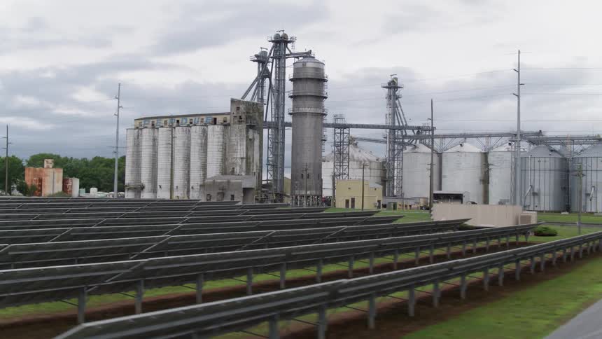 Solar panels and silos sit on a farm