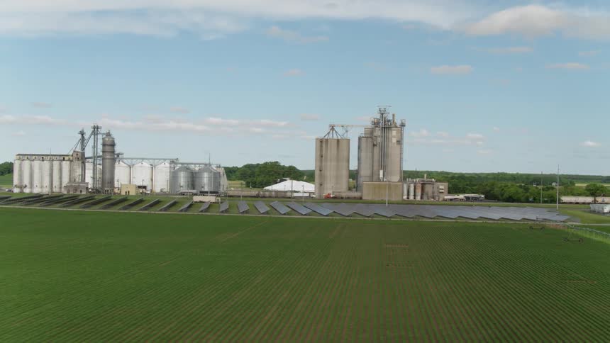 Solar panels and silos sit on a farm