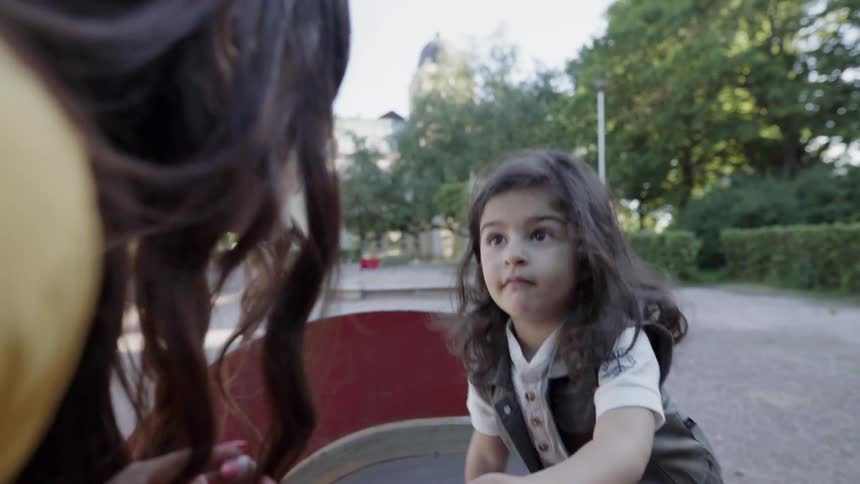 Woman tries to help a child playing on equipment at the park