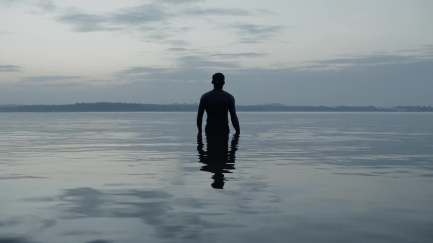 Man stands in the middle of still water