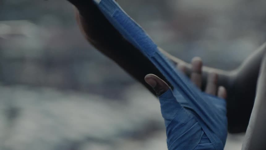Man wraps his hand in athletic tape