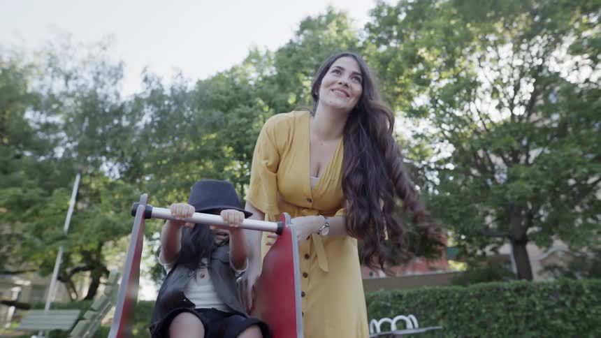 A woman and young child play at a park