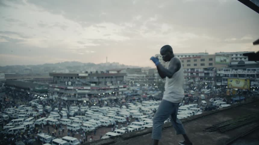 A boxer punches the air on a building rooftop