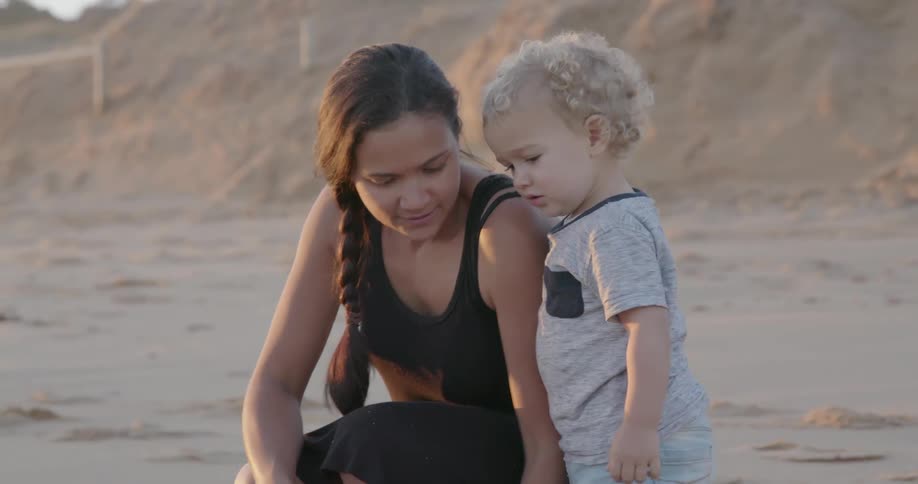 Man and woman playing in the sand on beach with child