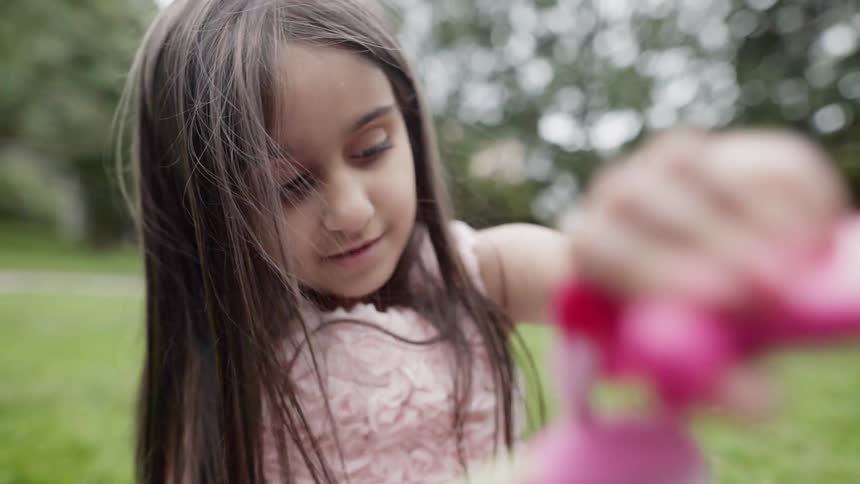 A girl plays on a grassy lawn