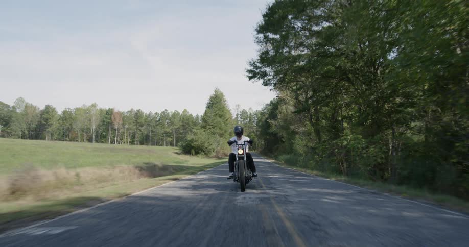 Man is riding motorcycle on sunny highway
