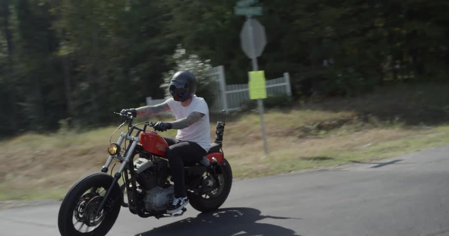 A man motorcycles on a rural road