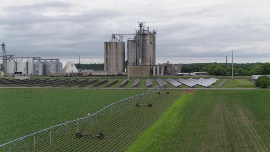 Solar panels and silos sit on a farm