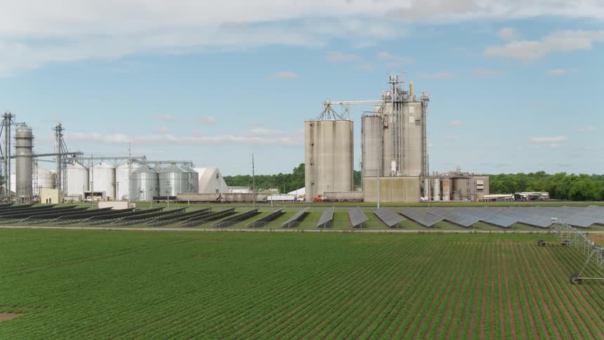Solar panels and silos sit on a farm