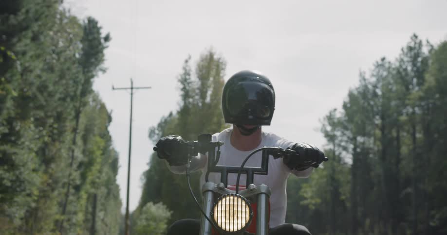 A man motorcycles on a rural road