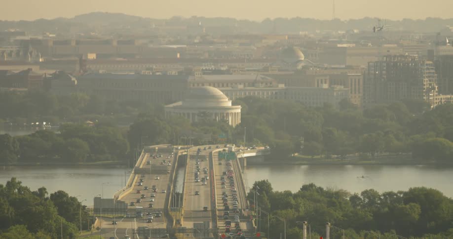 Vehicles drive on a bridge over a river into Washington DC