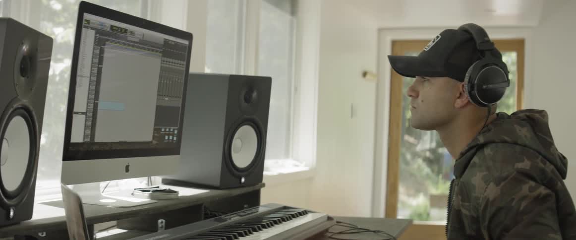 Man plays keyboard and looks at a computer
