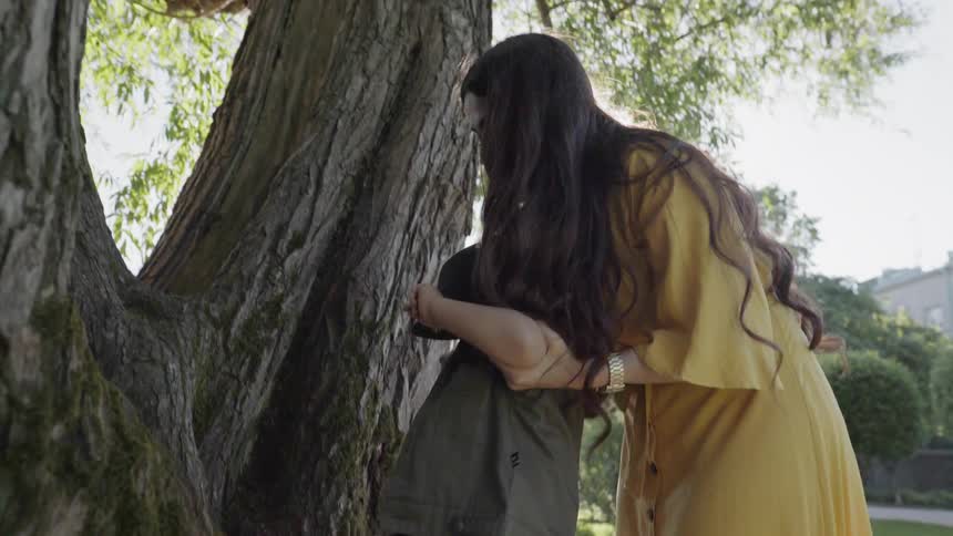 Woman helps a child climb a tree