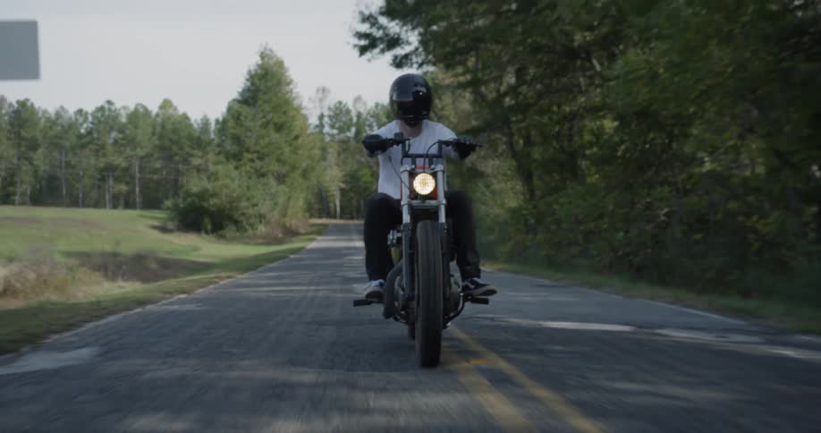 A motorcyclist rides on a rural road