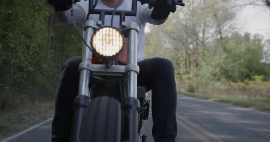 Man is riding motorcycle on country road