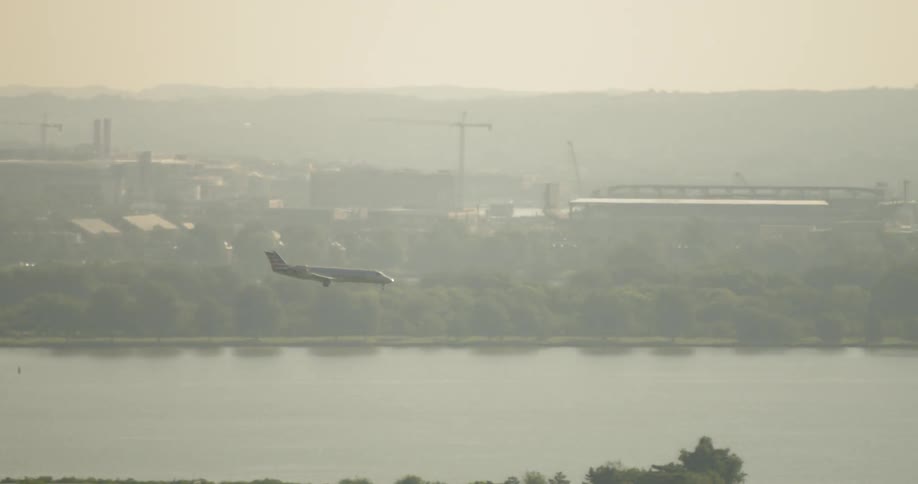 Airplane is coming in for landing in smoggy city