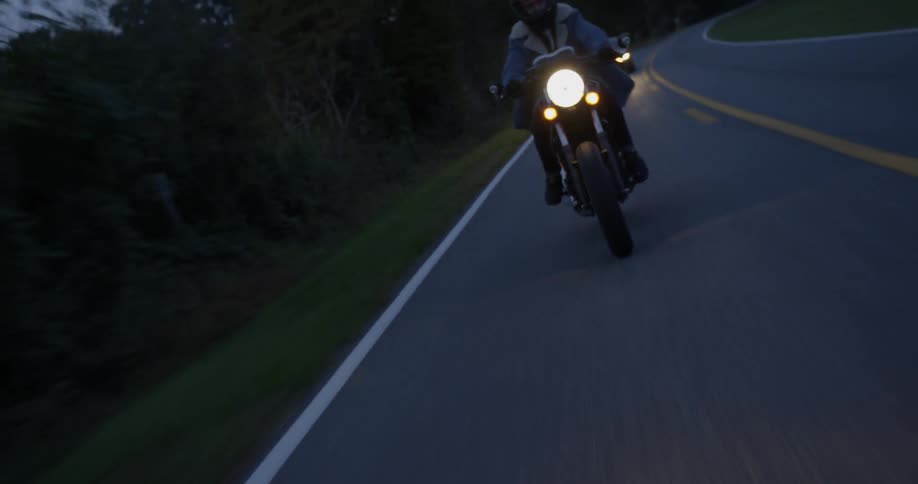 A man motorcycles on a rural road
