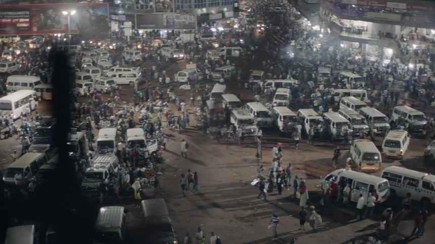 Vans and pedestrians cover a city parking lot