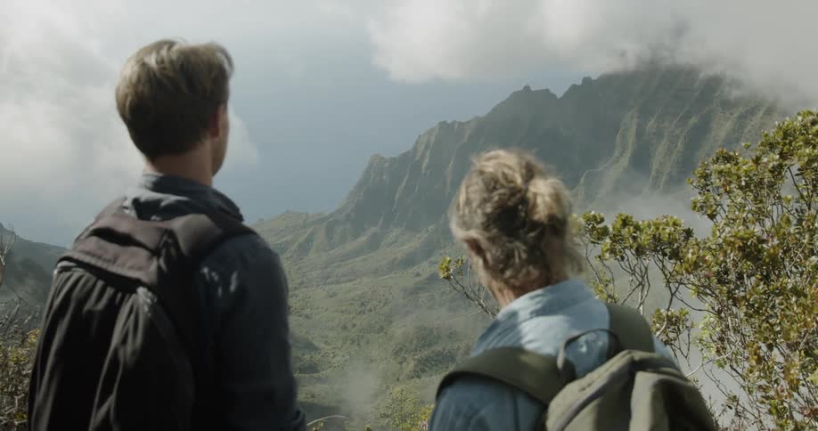 Two men stop to enjoy the view while hiking in mountains