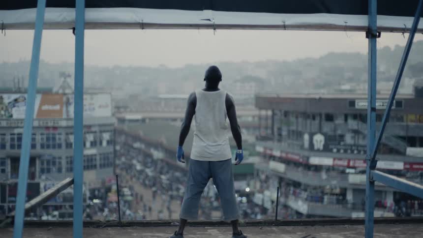 Man stands on a building rooftop at sunset