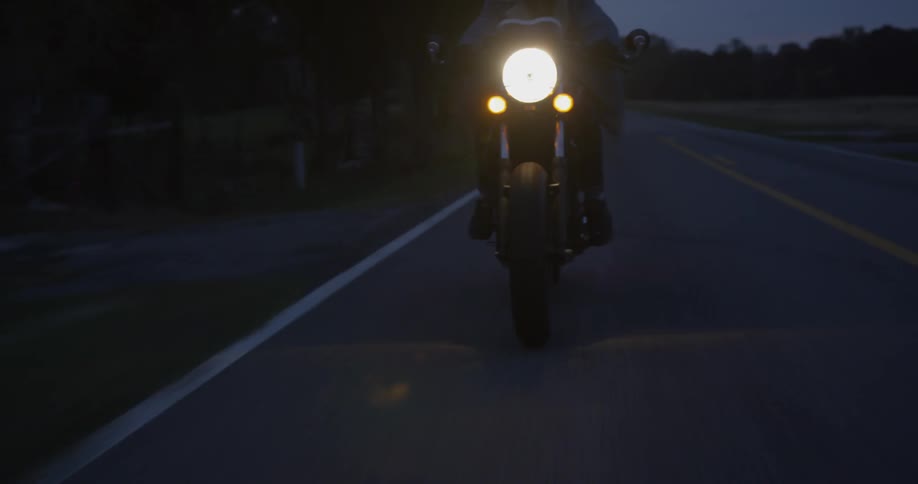 Person is riding motorcycle on highway at night
