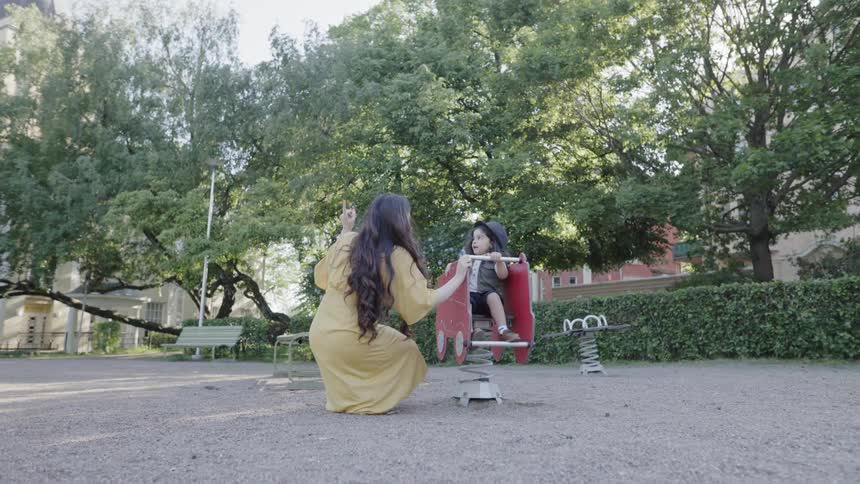 A woman and young child play at a park