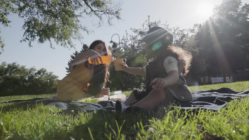 A woman and child picnic on a sunny day
