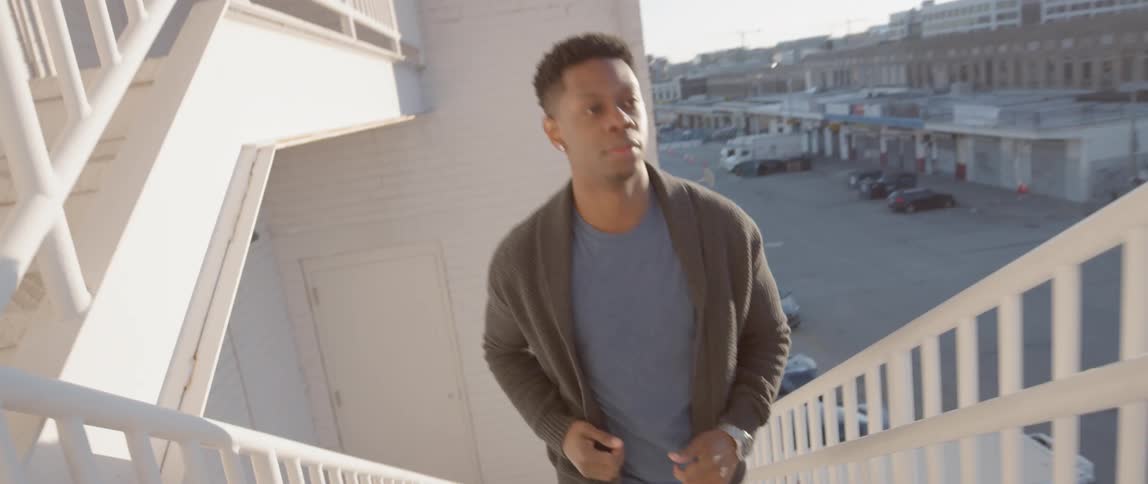Man runs up a white staircase under a sunny sky