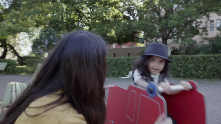 A mother and child play at a park