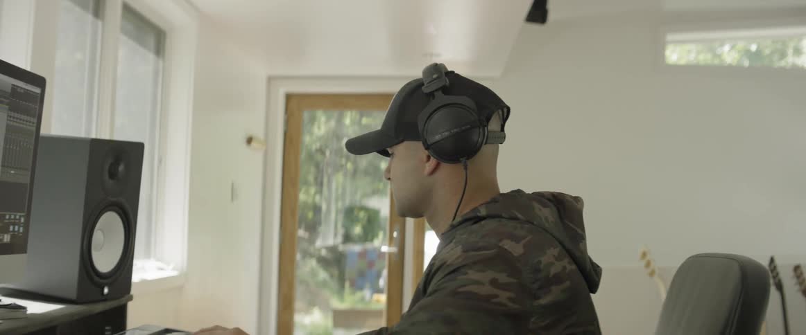 A man plays a keyboard in a music studio