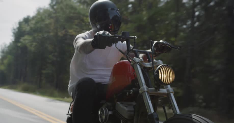 A motorcyclist rides a rural road