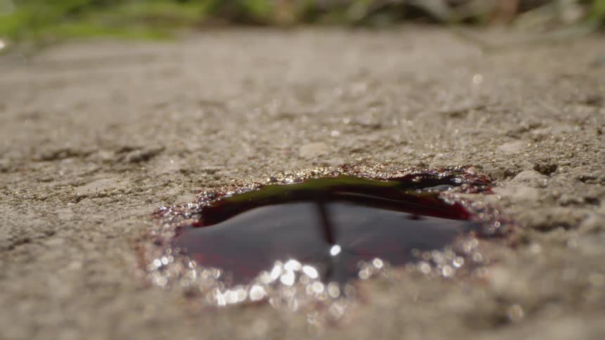 Black liquid drips onto the ground