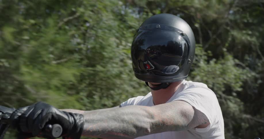 A motorcyclist travels through a forest