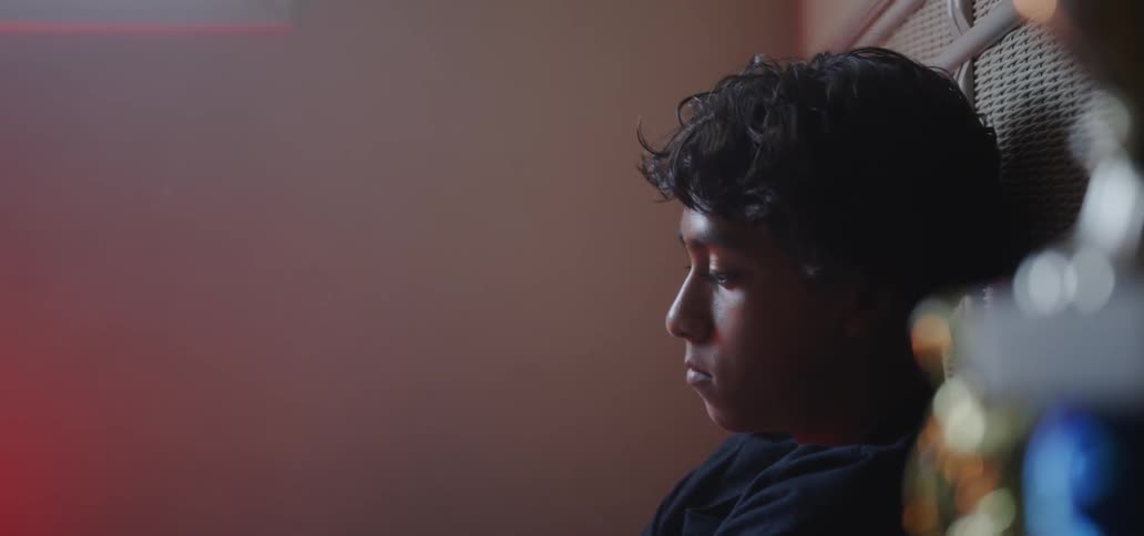 A teenager looks sad while sitting in bed
