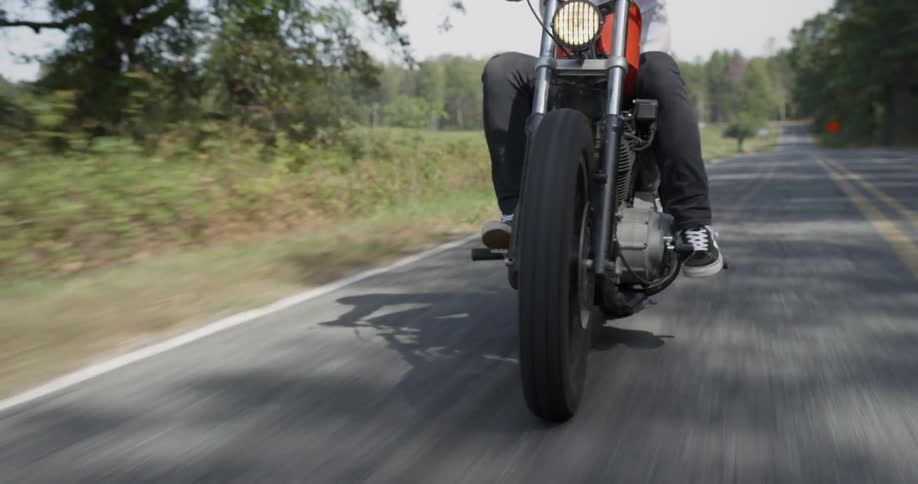 Man is riding motorcycle on sunny highway