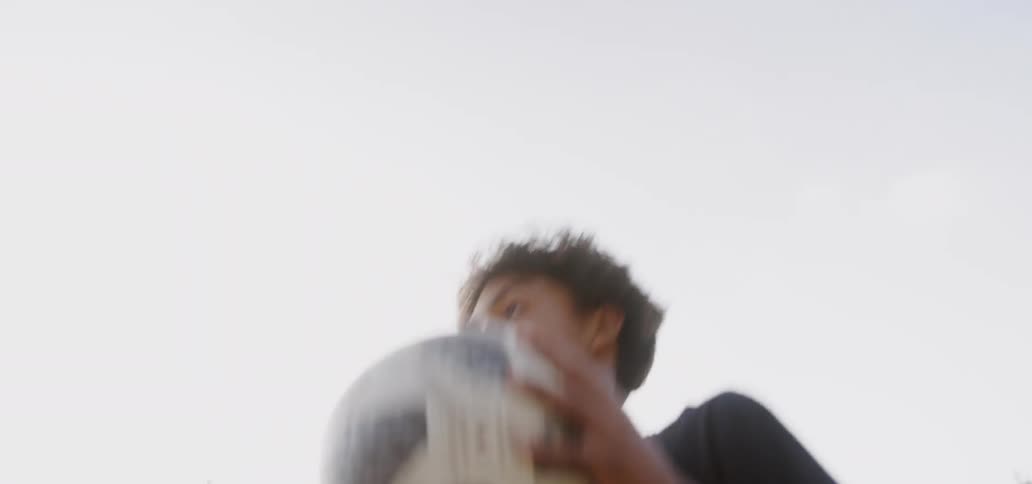 A teenager kicks a soccer ball in a field