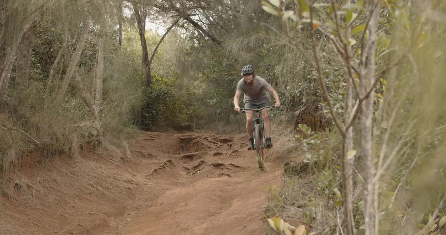 A bicyclist rides on a rural dirt path