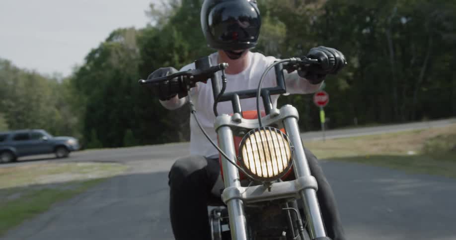 Man is riding motorcycle on street in town in sunny day