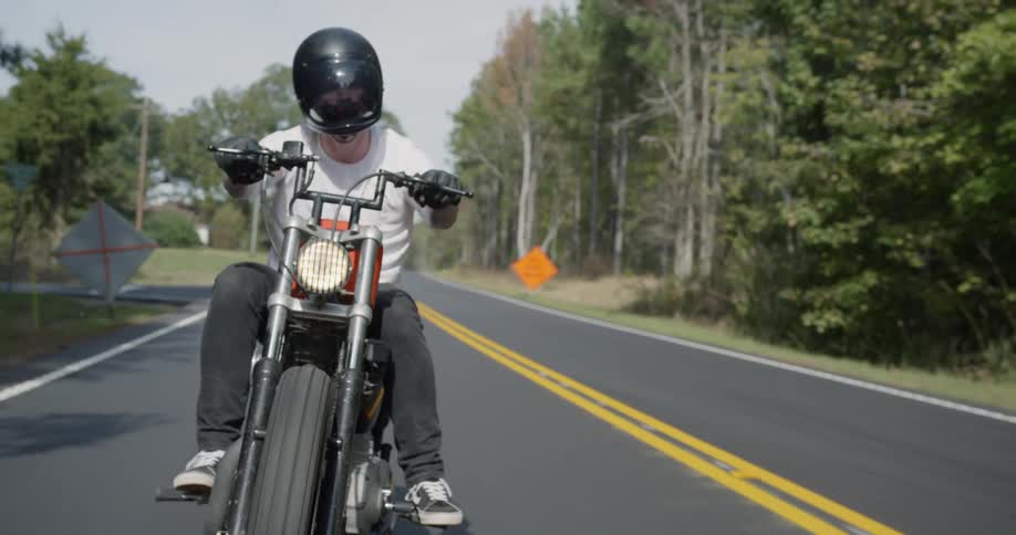 Man is riding motorcycle on sunny highway