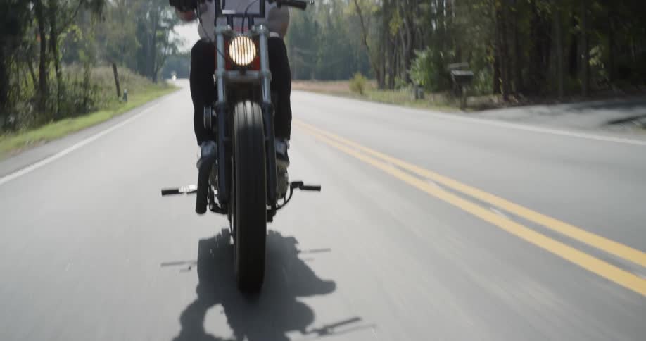 Man rides motorcycle down highway
