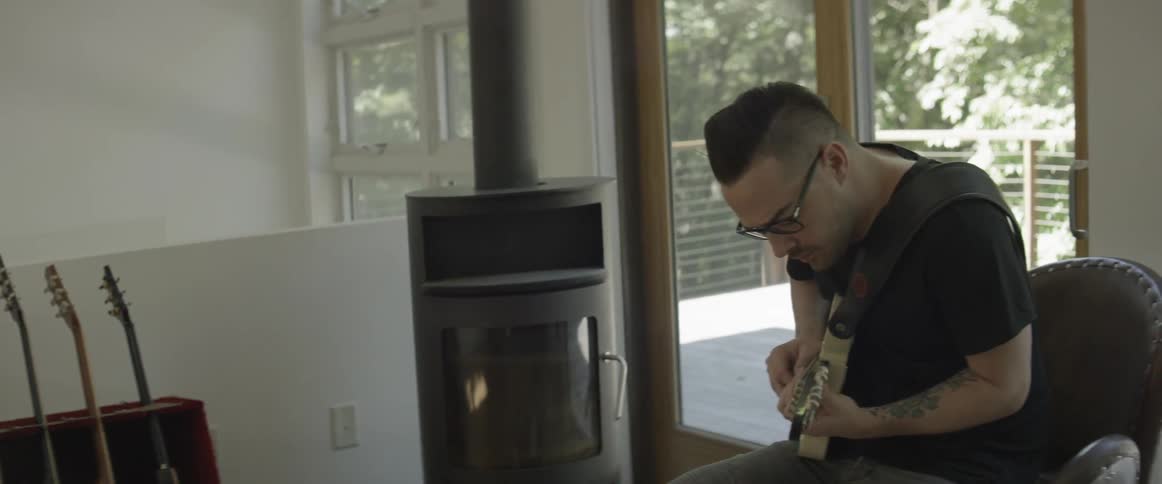 Man plays guitar in a music room
