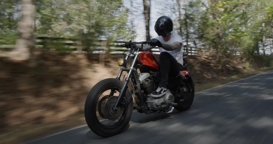 A man rides a motorcycle on a rural road