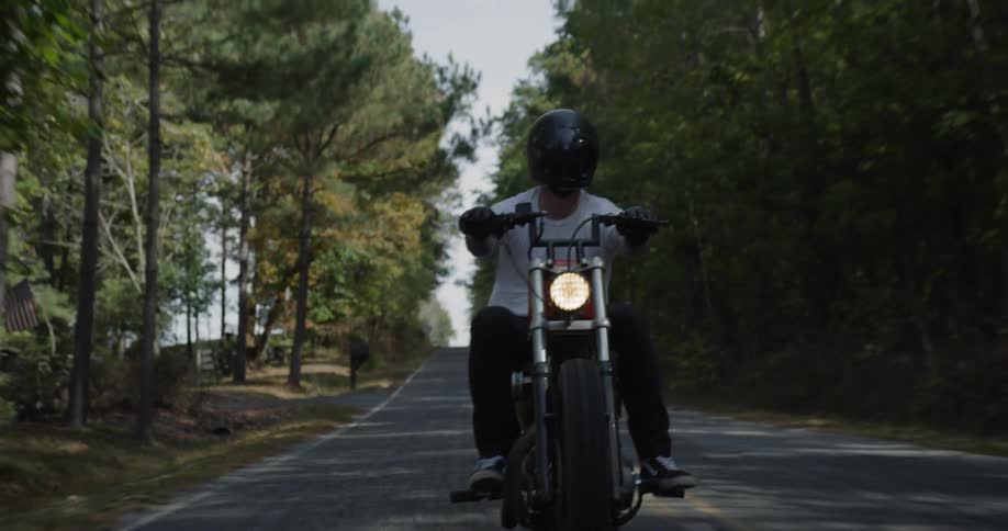 Man motorcycles on a rural road