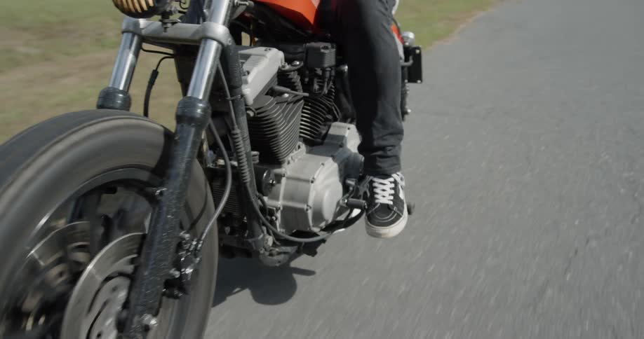 Man is riding motorcycle on sunny road
