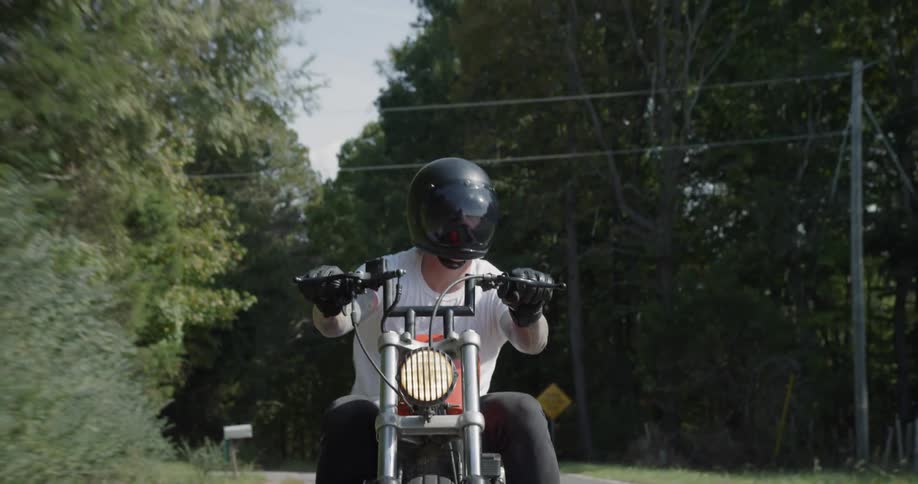 A motorcyclist rides on a rural road